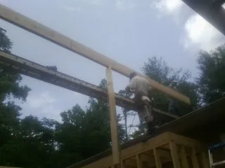 Carpenter setting a ridge beam over a new addition frame — Ice Dam Removal by Roofing Brothers in Milton Center