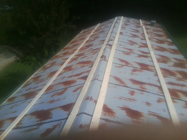 Rusted metal roof panels with new wood purlins before replacement — Storm Damage Roof Repair in Milton Center by Roofing Brothers