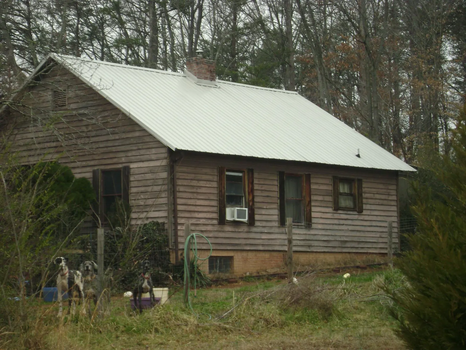 White metal roof on an old wood sided farmhouse, from a Metal Roof Installation job in Milton Center